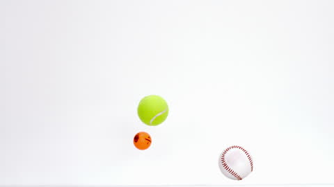Assorted Balls Dropping Against Minimal Background