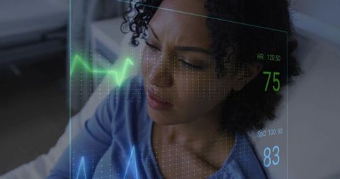 Reclining woman squinting, checking holographic vital signs display showing hr 75 spo2 83