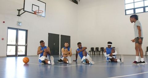 Team Stretching Exercises Before Basketball Training on Indoor Court