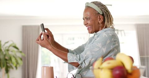 Joyful Senior Woman Video Calling with Smartphone at Home