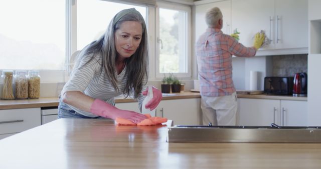 Middle aged caucasian couple cleaning kitchen at home, slow motion - Download Free Stock Photos Pikwizard.com