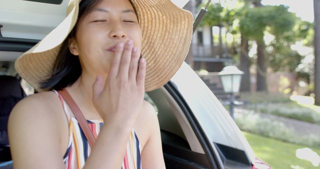 Smiling Woman in Sun Hat Blowing Kiss Outdoors Near Car - Download Free Stock Images Pikwizard.com