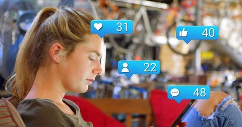 Woman checking phone notifications in bicycle workshop