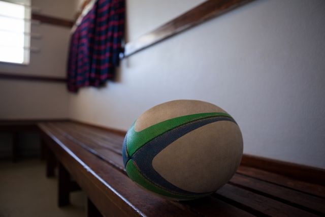 Close-up of rugby ball on bench in locker room