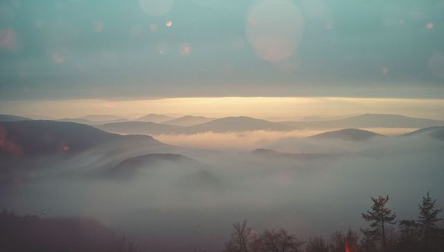 Serene Mountain Landscape with Foggy Horizon at Sunrise