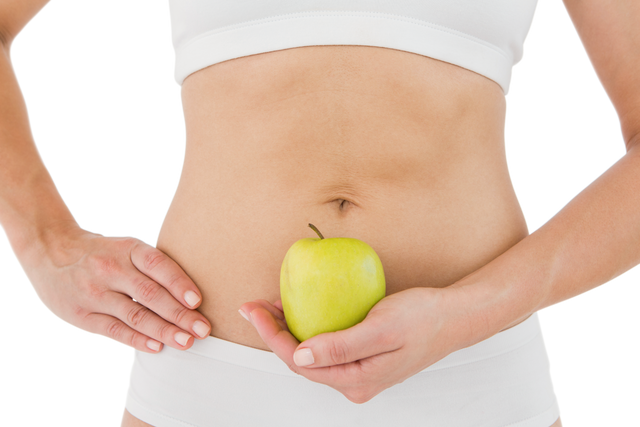 Transparent background fit woman holding green apple to abdomen promoting healthy eating - Download Free Stock Videos Pikwizard.com