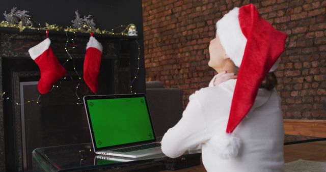 Woman Wearing Christmas Hat Using Laptop in Festive Living Room - Download Free Stock Images Pikwizard.com