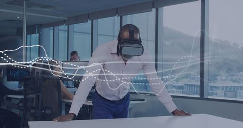 Businessman Using VR Headset for Data Visualization in Modern Office