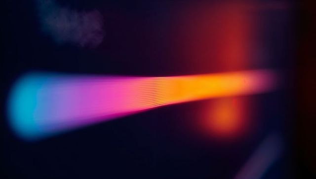 Glowing multicolored light streak with gradient in dark space