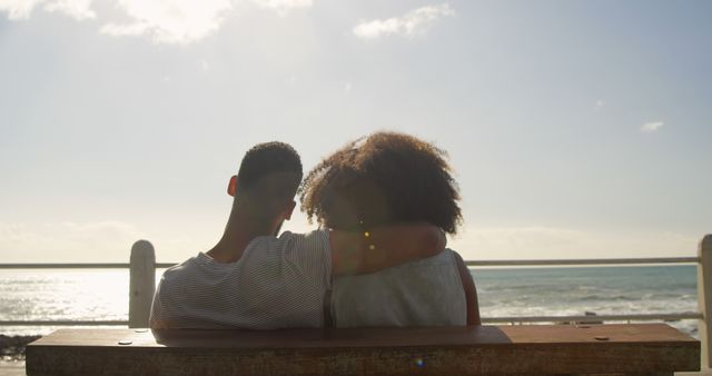 Romantic diverse couple sitting,embracing and looking on sea on sunny promenade, copy space - Download Free Stock Photos Pikwizard.com