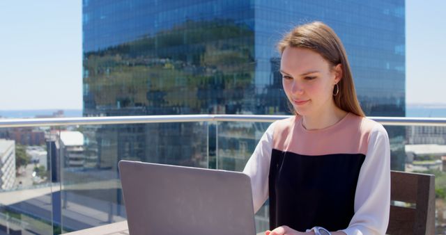 Smiling Young Woman Using Laptop on Outdoor Urban Balcony - Download Free Stock Images Pikwizard.com