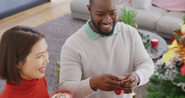Image of happy diverse couple decorating christmas tree at home - Download Free Stock Photos Pikwizard.com