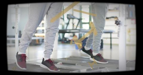 Jogging on treadmill with mirrored reflection, maroon black sneakers and grey joggers