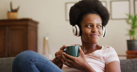 Relaxed Woman Enjoying Music While Holding Coffee Mug at Home