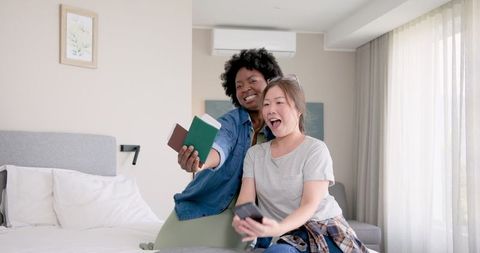 Joyful multiracial lesbian couple preparing for vacation