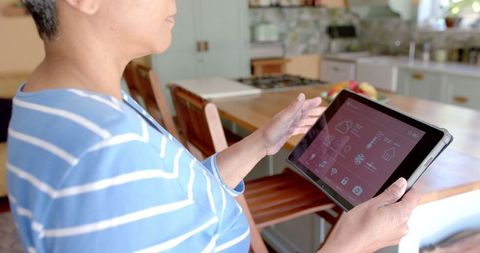 Senior Woman Using Tablet for Home Automation