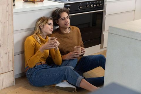 Smiling Couple Enjoys Coffee Together in Cozy Modern Kitchen