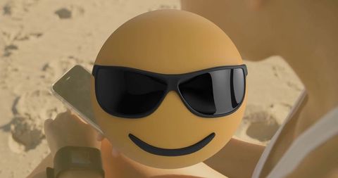 Emoticon with Sunglasses Floating Over Woman Relaxing at the Beach