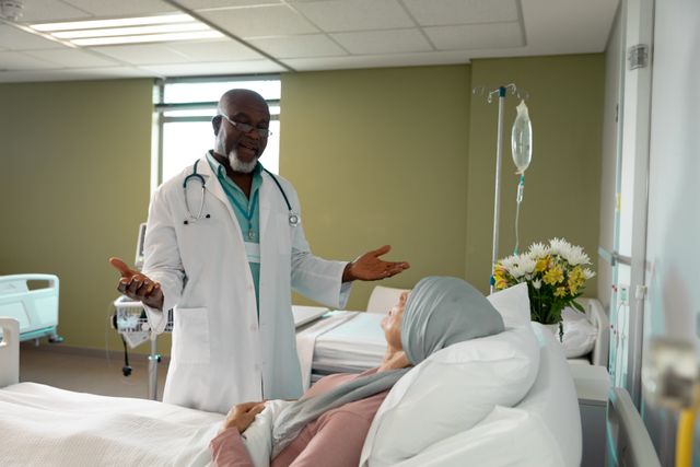 Senior doctor consulting with a patient in a hospital room. Ideal for use in healthcare, medical services, patient care, and hospital-related content. Can be used in articles, brochures, and websites focusing on medical treatment, elderly care, and healthcare services.