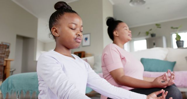 Mother and Daughter Meditating in Living Room with Relaxed Expressions - Download Free Stock Images Pikwizard.com