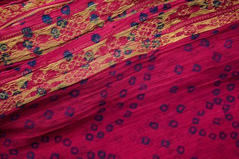 Vibrant pink silk textile featuring gold brocade stripes and indigo dot motifs