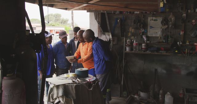 Team of Auto Mechanics Gathering Around Tablet Looking at Instructions - Download Free Stock Images Pikwizard.com