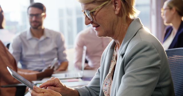 Senior Businesswoman Using Digital Tablet in Meeting - Download Free Stock Images Pikwizard.com