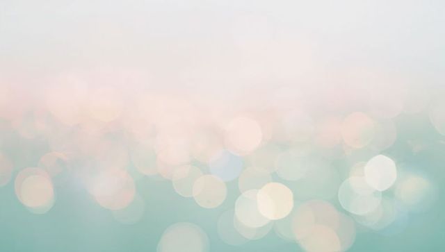 Dreamy pastel bokeh background with soft teal and peach light orbs for elegant layouts