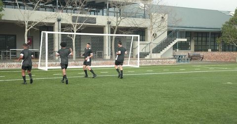 Teen soccer players training for teamwork on school field