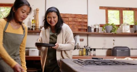 Two Women Baking Together Holding Fluted Tart Pan in Cozy Rustic Kitchen