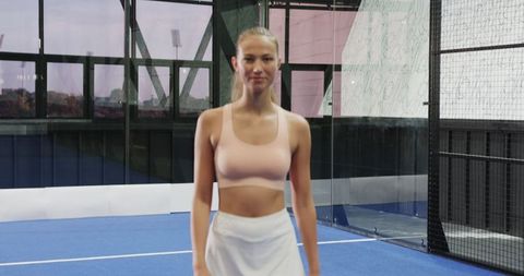 Focused female athlete standing on modern blue synthetic court