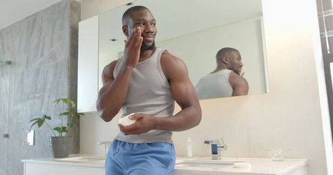 Man Applying Face Cream in Stylish Modern Bathroom