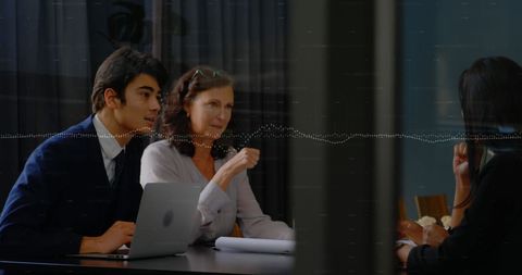 Colleagues engaged in discussion in modern conference room