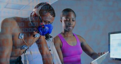 Cardiopulmonary fitness testing with metabolic mask and sensors, trainer checking tablet
