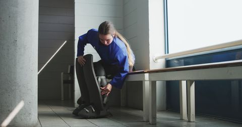 Female hockey player dressing for game in locker room