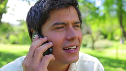 Man Talking on Cell Phone in Green Park Atmosphere