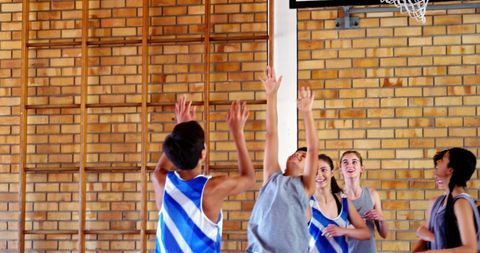 Energetic youth playing basketball in indoor court