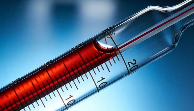 Macro close-up of glass graduated cylinder with red liquid column and precise calibration