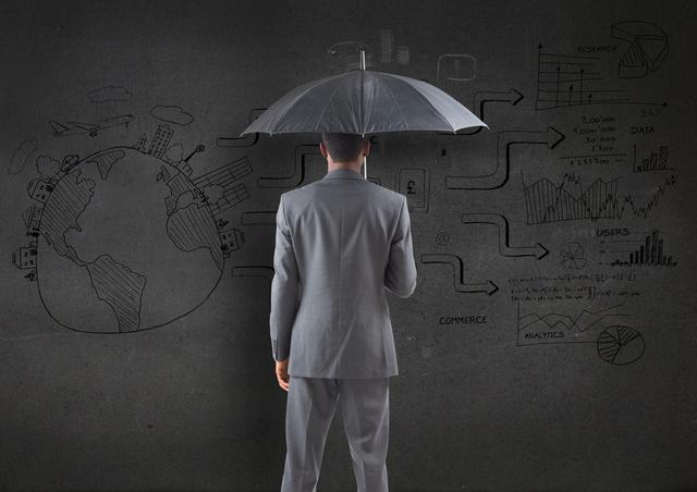 Digital composition of businessman holding an umbrella against business plan sketch on blackboard