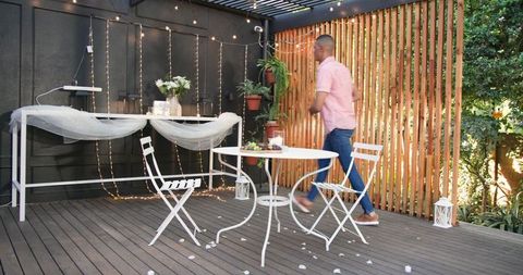 Man Creating Romantic Atmosphere on Cozy Patio