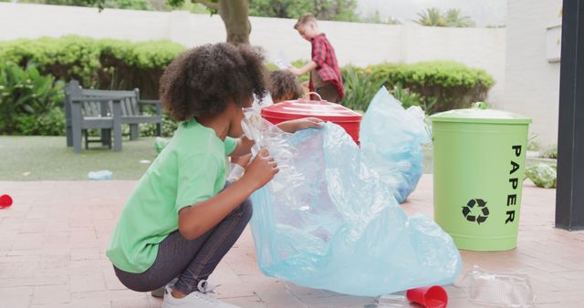 Children are seen engaging in recycling activities in a green garden. They are sorting and placing recyclable materials into appropriate bins, promoting environmental awareness and teamwork. Great for educational materials, environmental campaigns, and sustainability projects.