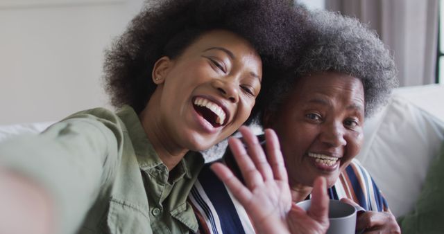 Happy african american adult daughter and senior mother taking selfies, slow motion - Download Free Stock Photos Pikwizard.com