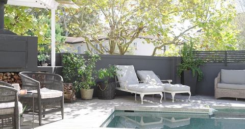 Peaceful Sunlit Backyard with Lounge Chairs by Pool