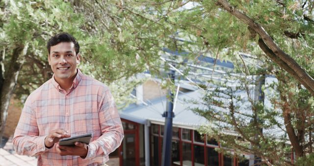 Smiling Young Man Using Tablet Outdoors in Courtyard - Download Free Stock Images Pikwizard.com