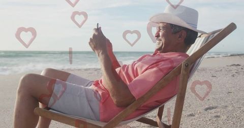 Senior Man Enjoying Beach with Smartphone and Love Hearts Icons