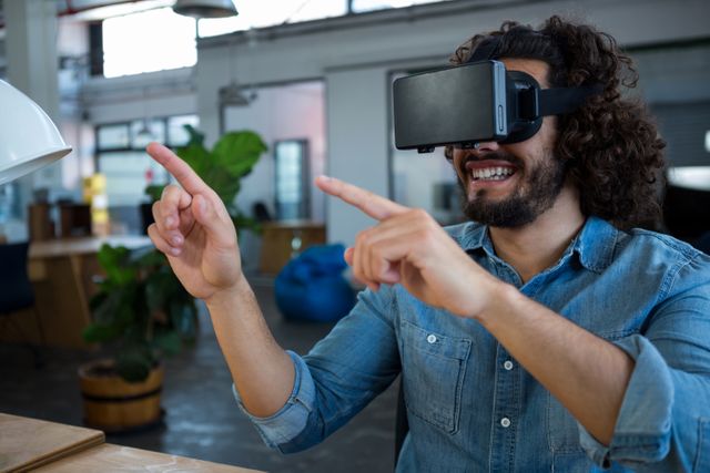 Graphic designer wearing virtual reality headset, engaging with digital content in a creative office environment. Ideal for showcasing modern technology in the workplace, digital and virtual innovation, or VR applications in design and creative industries.