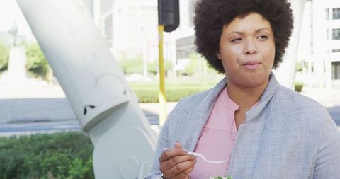 Confident Woman Enjoying Healthy Salad in Urban Environment