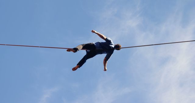 Highlining daredevil balancing against blue sky - Download Free Stock Images Pikwizard.com