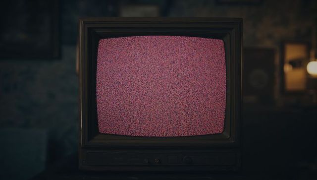 Vintage CRT Television Displaying Pink Static with Dim Room Ambiance