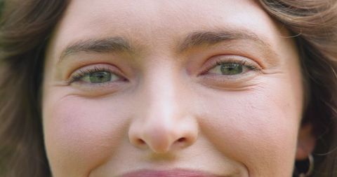 Close-Up Portrait of Woman with Green Eyes in Garden